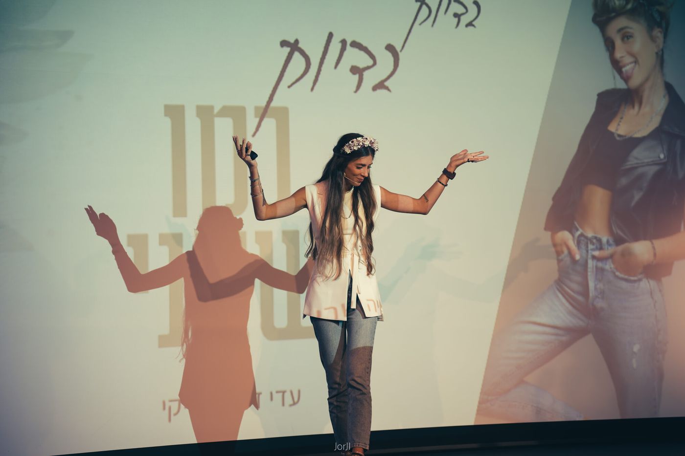 עדי על הבמה, ידיים פתוחות, באמצע הרצאה